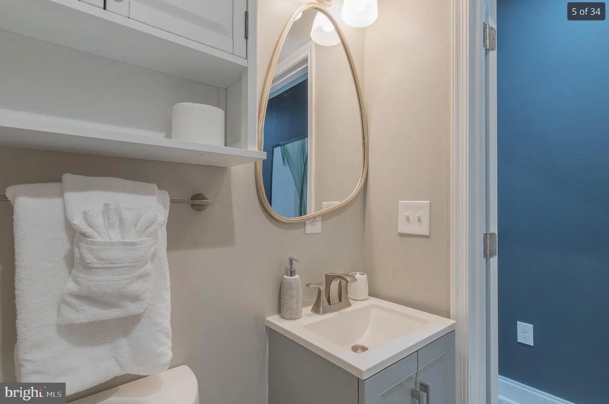 3221 Noble Street, Unit 3 Baltimore, MD 21224 - Photo 18 of 20 a bathroom with a sink a toilet and a mirror