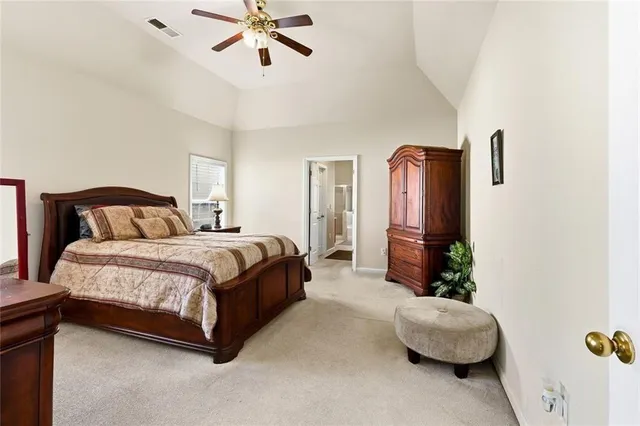 a spacious bedroom with a bed and ceiling fan