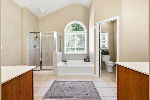 a spacious bathroom with a tub shower and a sink