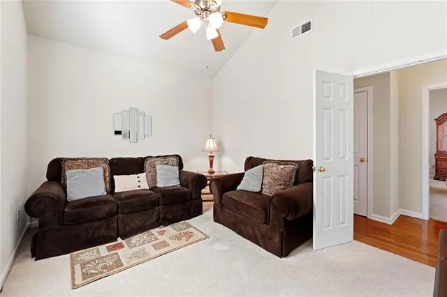 a living room with couches and large closet with wooden floor