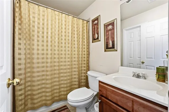 a bathroom with a sink a toilet and shower curtain