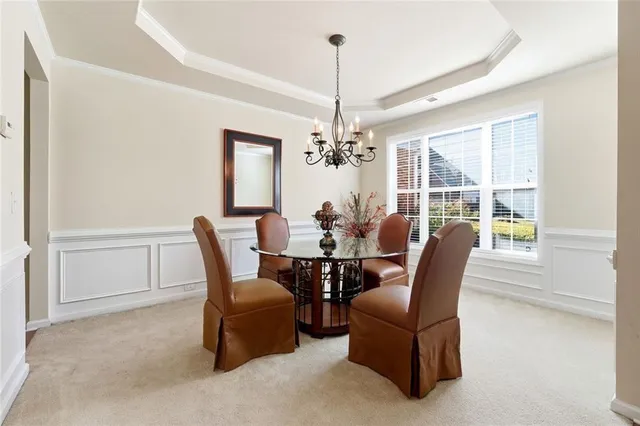 a dining room with furniture a chandelier and window