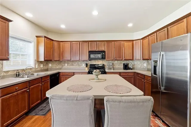 a kitchen with a sink a stove a refrigerator and cabinets