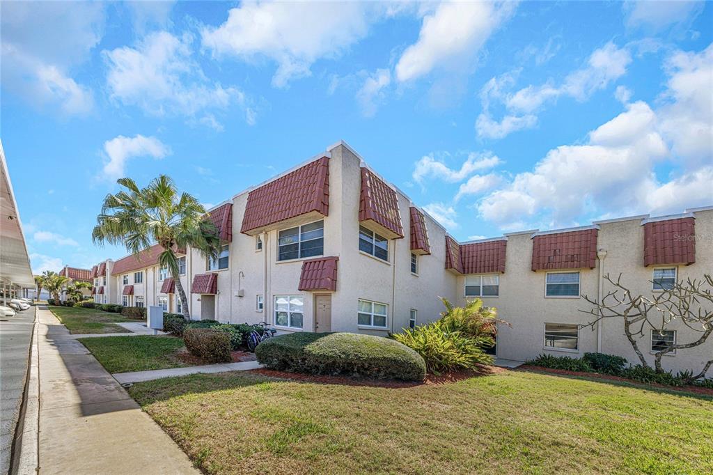 10032 65th Avenue North, Unit 9 St. Petersburg, FL 33708 - Photo 1 of 18 a front view of a house with a yard