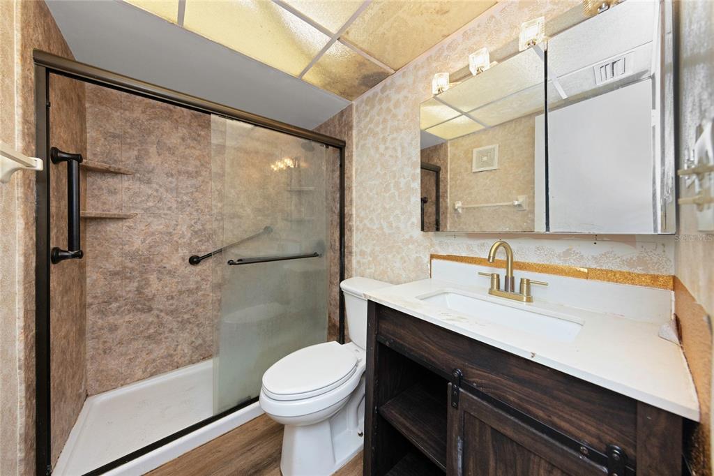 10032 65th Avenue North, Unit 9 St. Petersburg, FL 33708 - Photo 13 of 18 a bathroom with a sink a toilet a mirror and shower