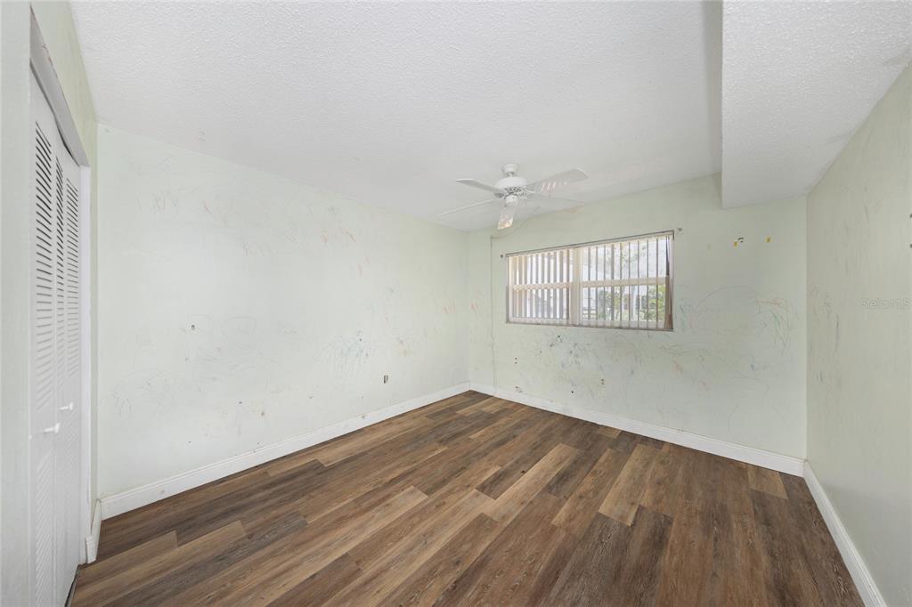 10032 65th Avenue North, Unit 9 St. Petersburg, FL 33708 - Photo 14 of 18 an empty room with wooden floor and windows
