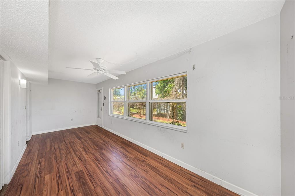 10032 65th Avenue North, Unit 9 St. Petersburg, FL 33708 - Photo 16 of 18 an empty room with wooden floor and windows