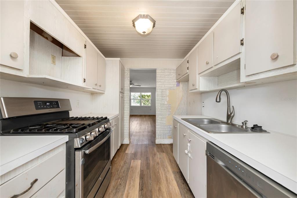 10032 65th Avenue North, Unit 9 St. Petersburg, FL 33708 - Photo 6 of 18 a kitchen with a sink a stove and cabinets