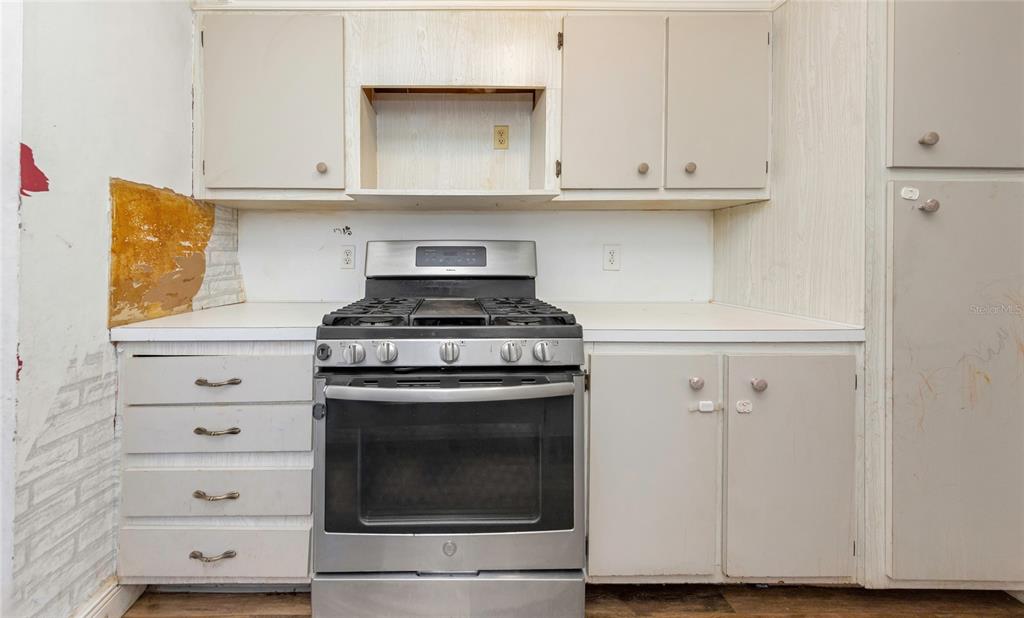 10032 65th Avenue North, Unit 9 St. Petersburg, FL 33708 - Photo 7 of 18 a kitchen with white cabinets and a stove with a sink