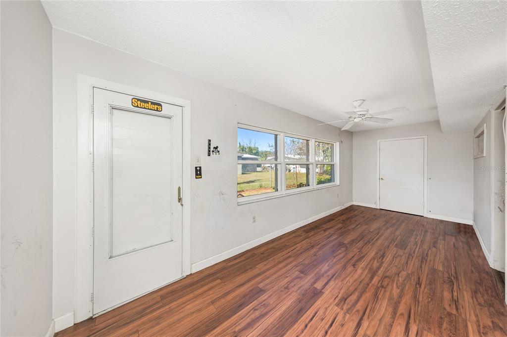 10032 65th Avenue North, Unit 9 St. Petersburg, FL 33708 - Photo 10 of 18 a view of an empty room with wooden floor and a window