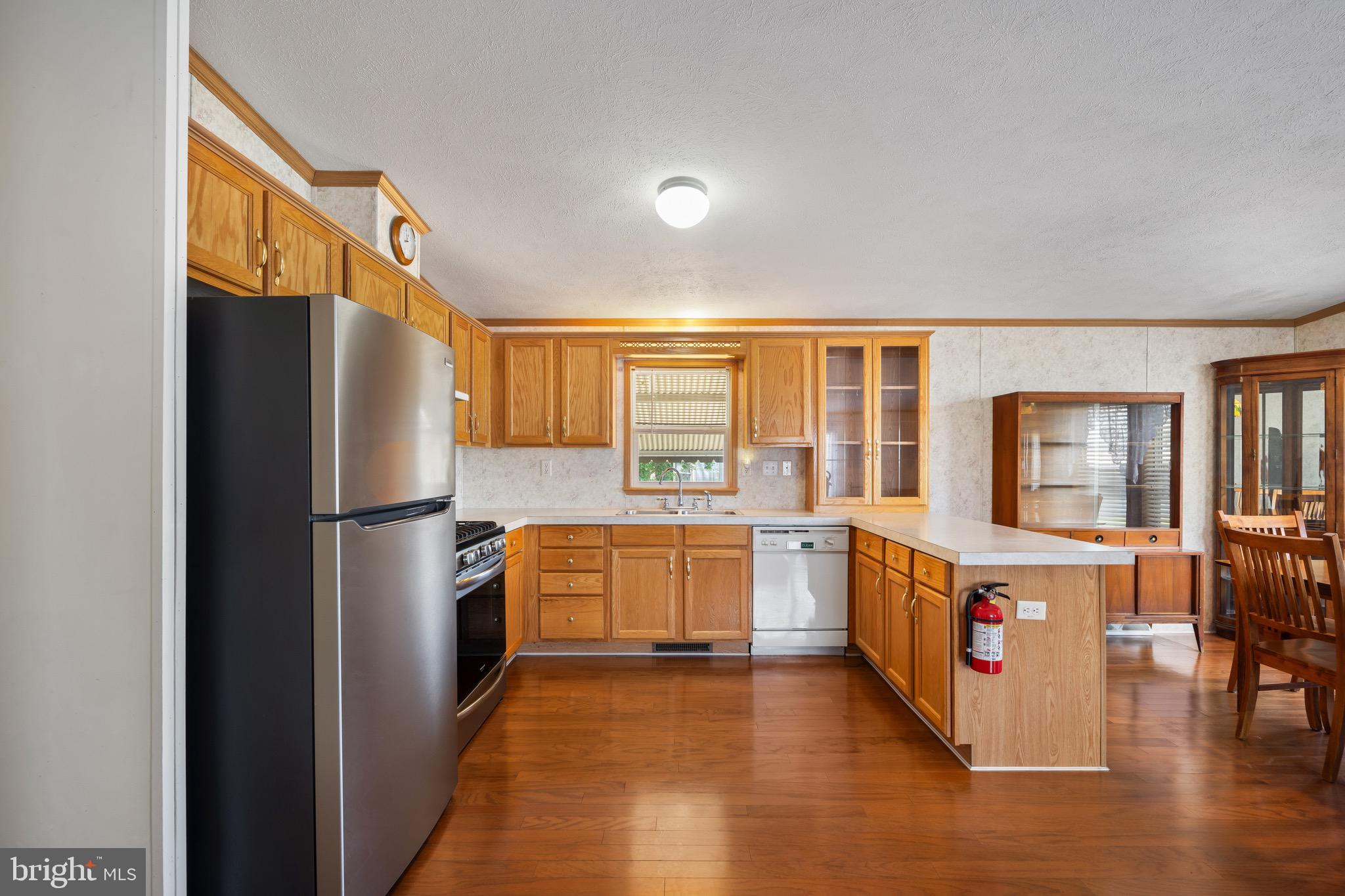 29 Oak Drive, Unit D Sicklerville, NJ 08081 - Photo 11 of 23 a kitchen with stainless steel appliances a stove a refrigerator and wooden cabinets