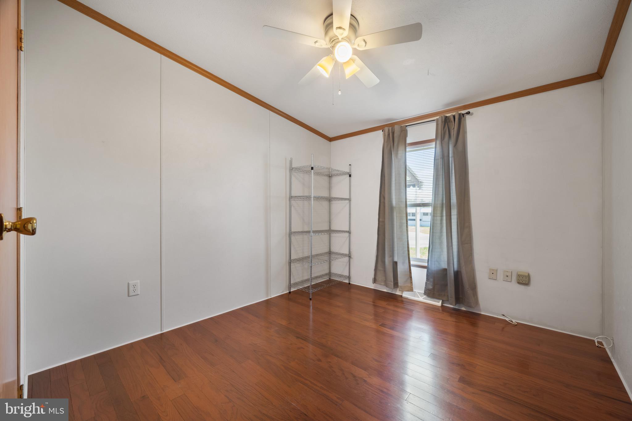 29 Oak Drive, Unit D Sicklerville, NJ 08081 - Photo 21 of 23 an empty room with wooden floor chandelier fan and windows