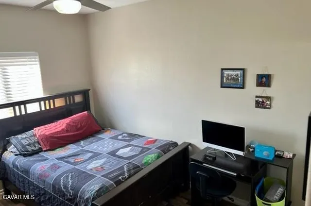 a bedroom with a bed and a computer on a table