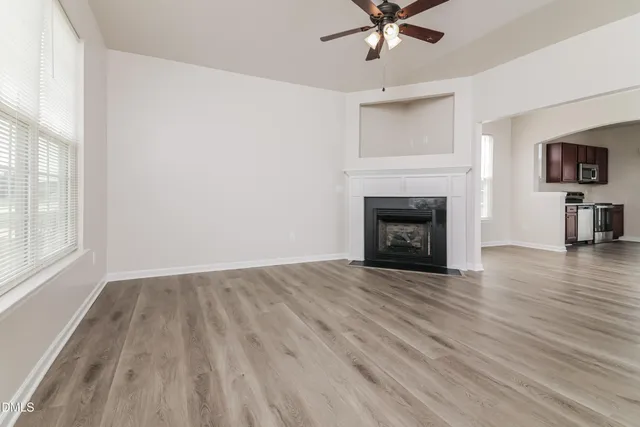 wooden floor fireplace and windows in an empty room