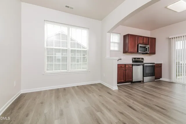 a view of kitchen with wooden floor and electronic appliances