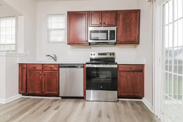 a kitchen with stainless steel appliances granite countertop a stove a sink and a microwave