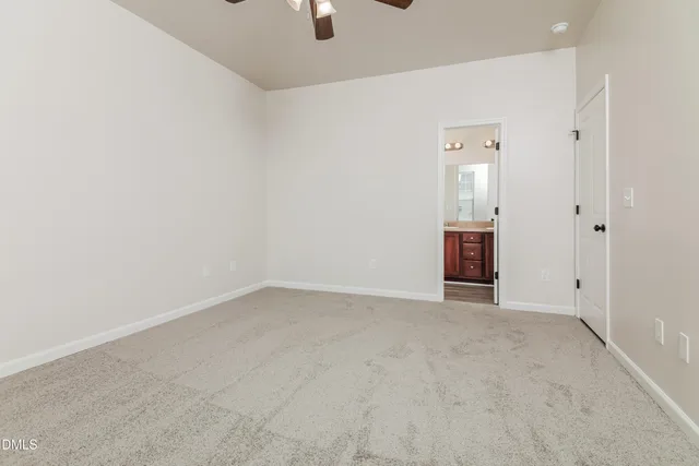 an empty room with fan and mirror