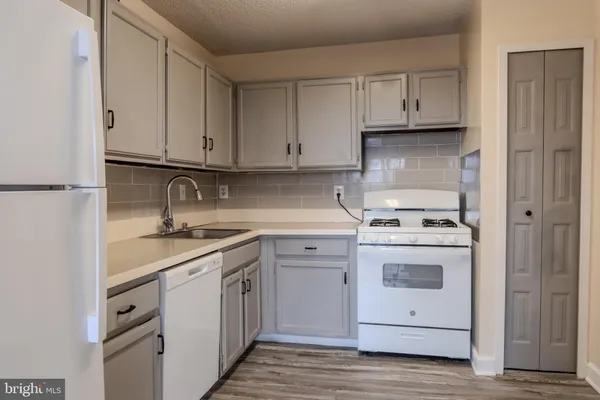 a kitchen with white cabinets and white appliances