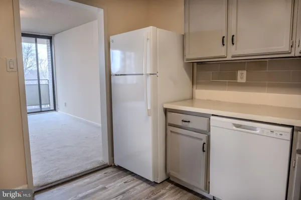 a kitchen with cabinets and a refrigerator