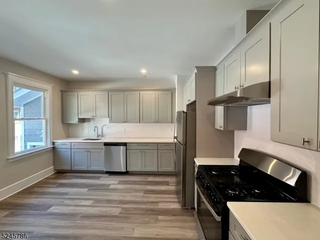 a kitchen with granite countertop a stove a sink and a refrigerator