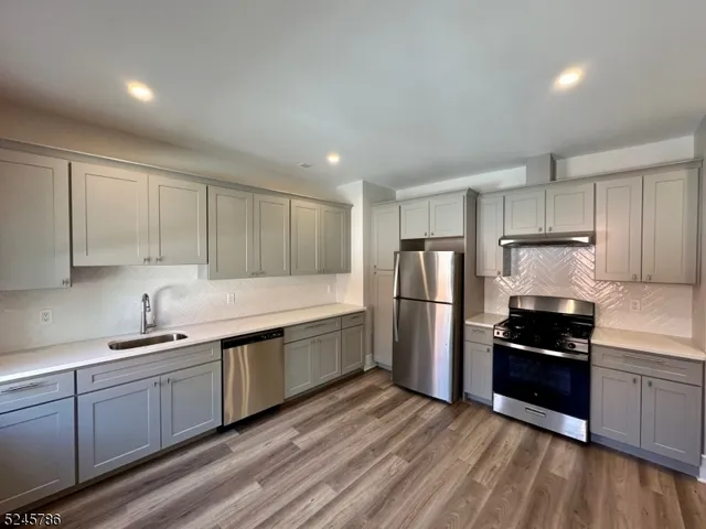 a kitchen with stainless steel appliances a refrigerator sink and cabinets