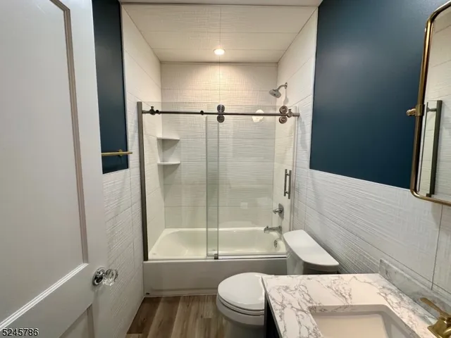 a bathroom with a bathtub shower sink vanity and toilet