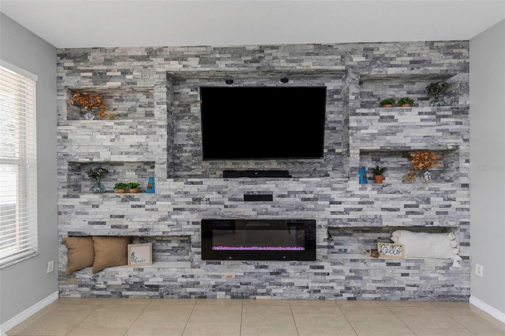 14818 Edgemere Drive Spring Hill, FL 34609 - Photo 16 of 72 a living room with a fireplace and a flat screen tv