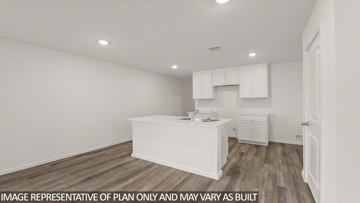 a view of a kitchen with white cabinets and wooden floor