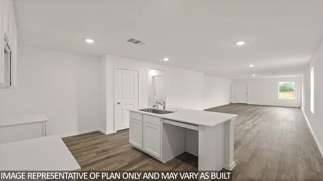a view of a kitchen with a sink and dishwasher with wooden floor
