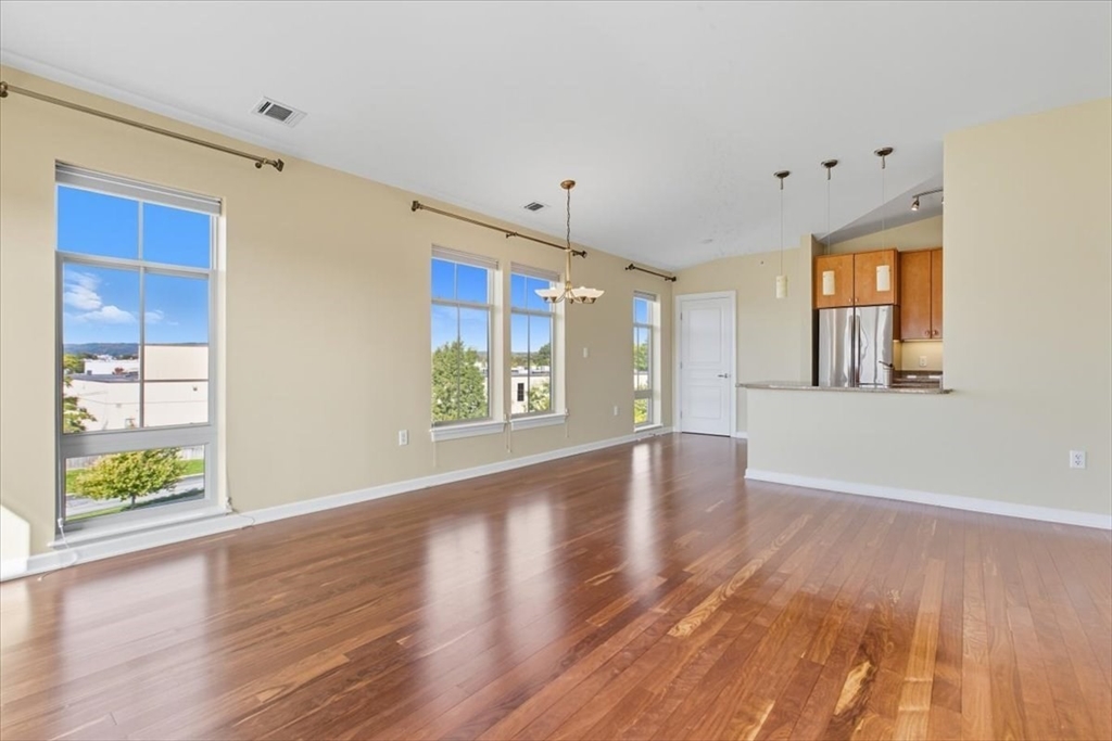 4 Repton Place, Unit 4410 Watertown, MA 02472 - Photo 1 of 41 a view of an empty room with window and wooden floor