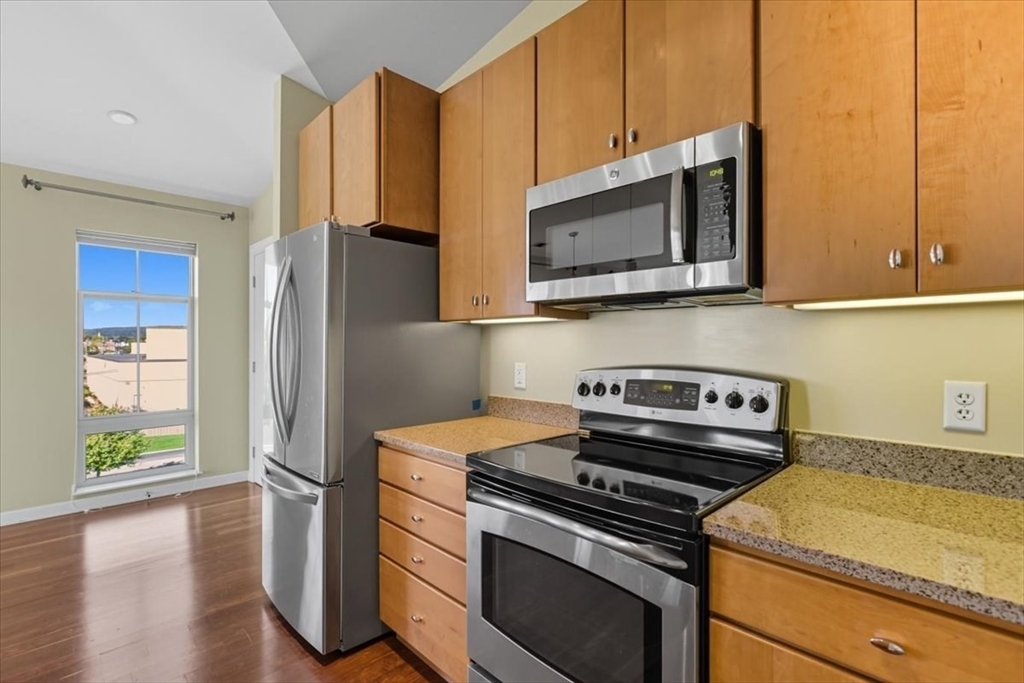 4 Repton Place, Unit 4410 Watertown, MA 02472 - Photo 11 of 41 a kitchen with a stove microwave and refrigerator