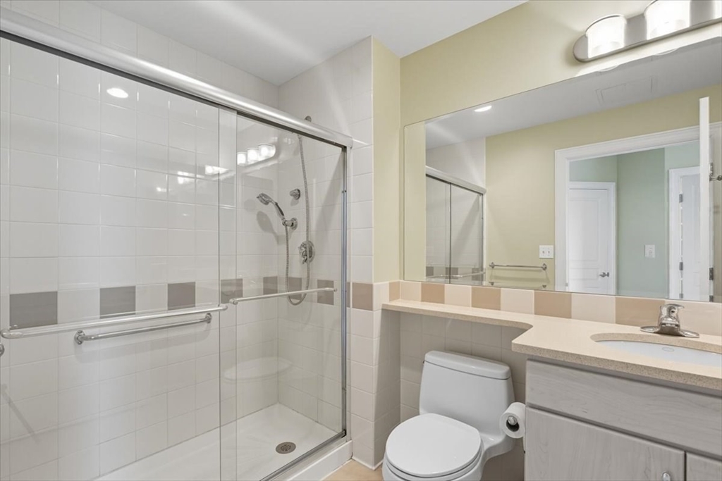 4 Repton Place, Unit 4410 Watertown, MA 02472 - Photo 19 of 41 a bathroom with a toilet sink shower and mirror