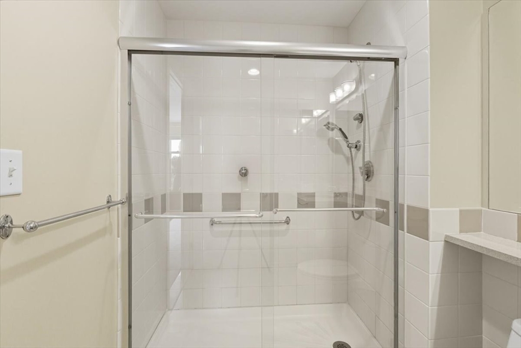 4 Repton Place, Unit 4410 Watertown, MA 02472 - Photo 21 of 41 a bathroom with a glass shower door