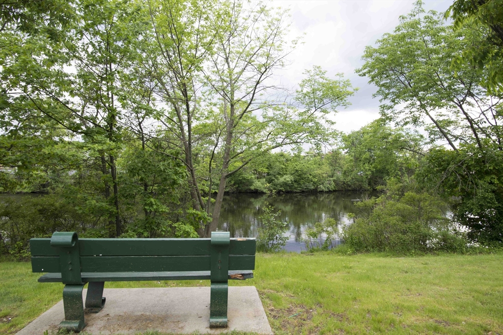 4 Repton Place, Unit 4410 Watertown, MA 02472 - Photo 38 of 41 a wooden bench sitting next to a lake