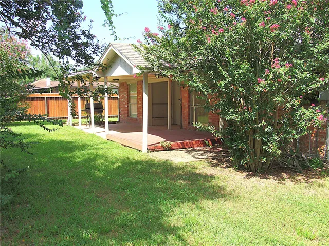 a view of a house with a yard and tree