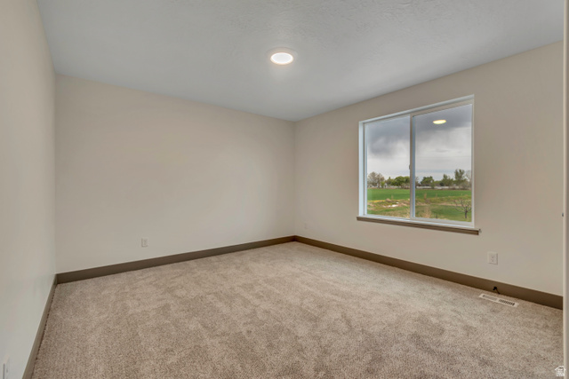 3317 South 1000 West, Unit 6010 Logan, UT 84321 - Photo 25 of 34 Carpeted spare room featuring baseboards