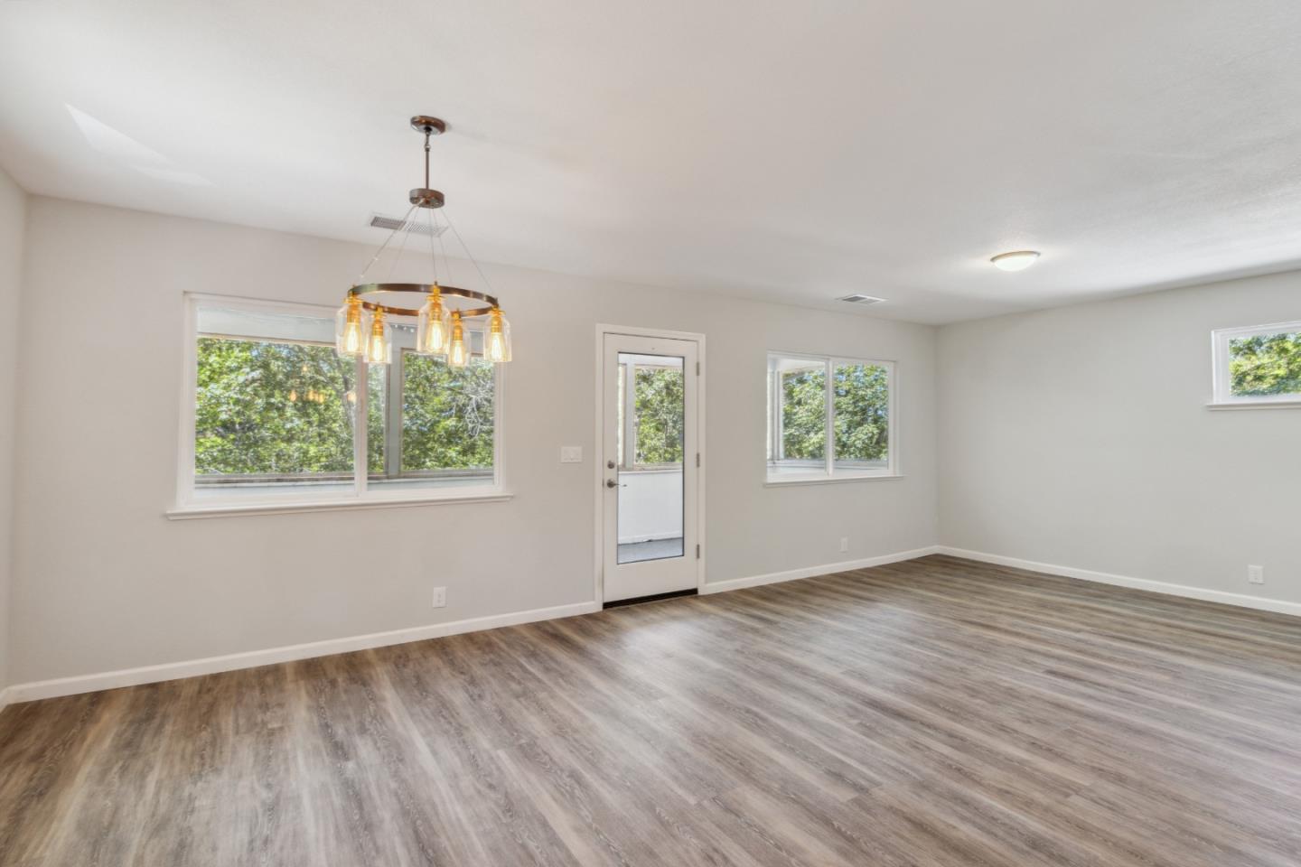 24895 Skyland Road Los Gatos, CA 95033 - Photo 11 of 113 an empty room with wooden floor and windows