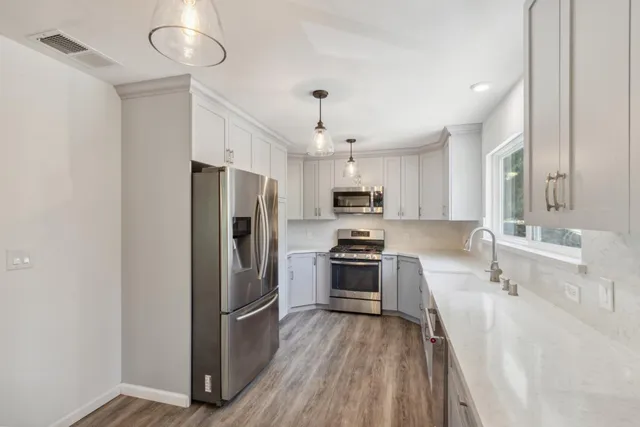 a kitchen with granite countertop white cabinets and white appliances