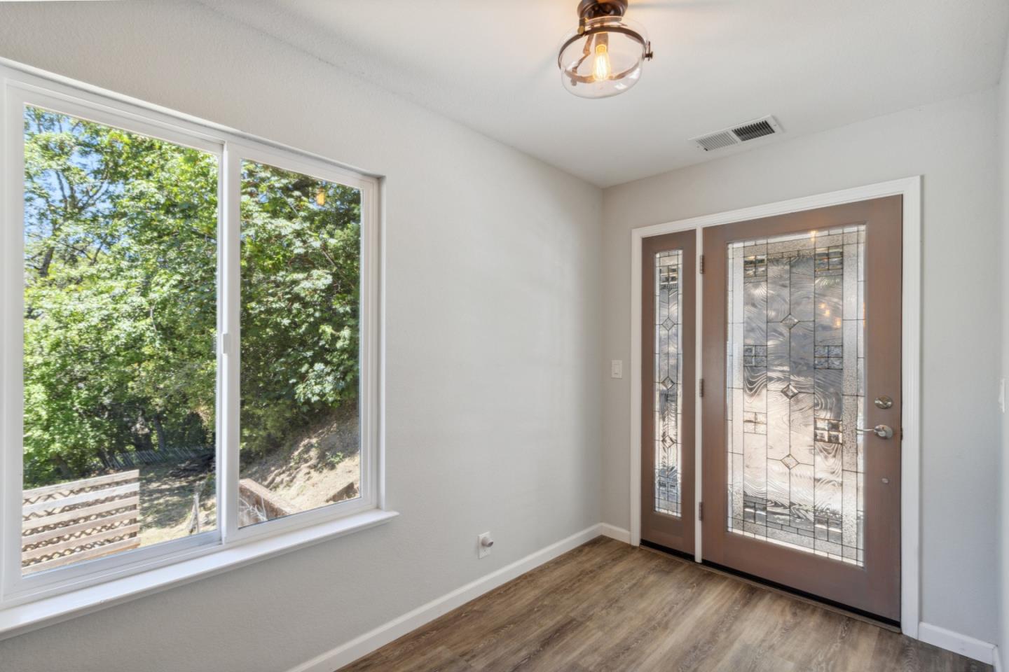 24895 Skyland Road Los Gatos, CA 95033 - Photo 4 of 113 a view of an empty room with wooden floor and a window