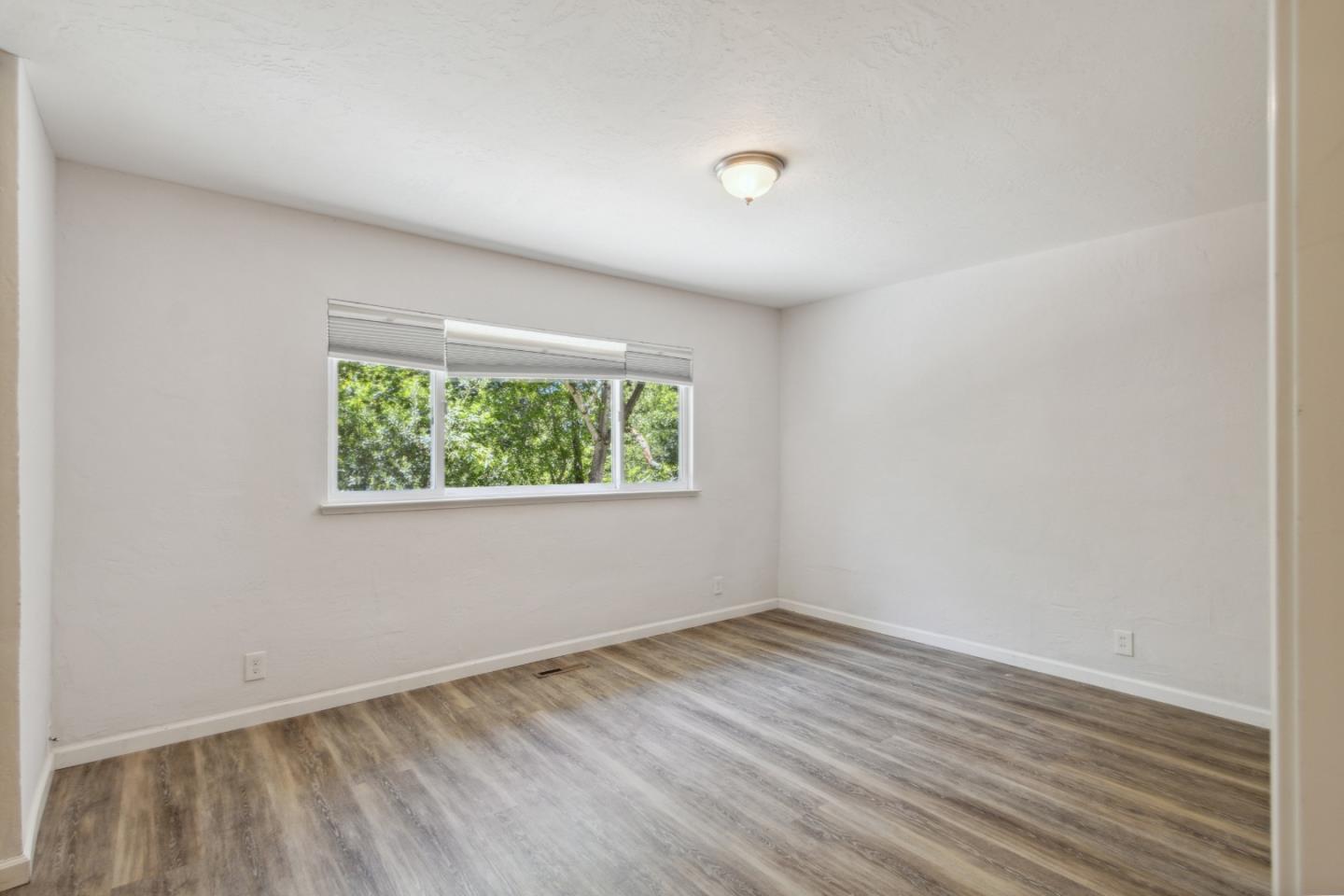 24895 Skyland Road Los Gatos, CA 95033 - Photo 41 of 113 an empty room with wooden floor and windows