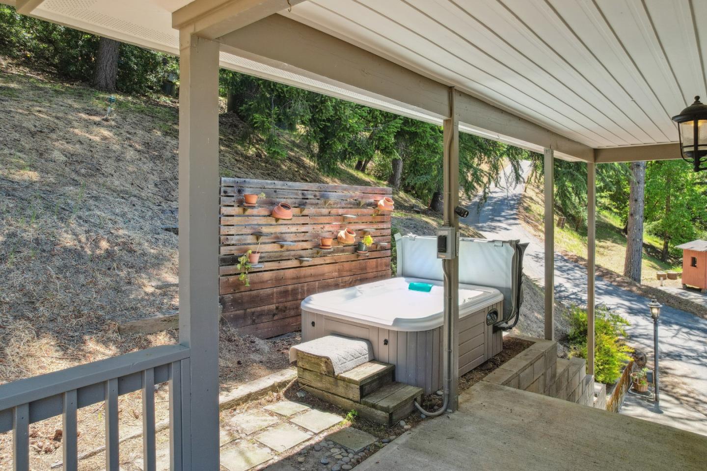24895 Skyland Road Los Gatos, CA 95033 - Photo 54 of 113 a view of a patio with table and chairs potted plants with wooden floor and fence