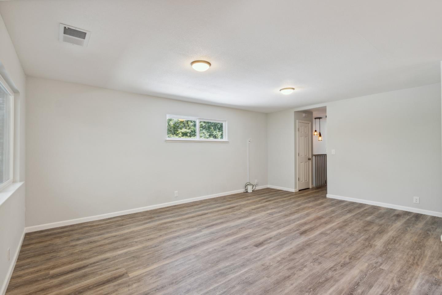 24895 Skyland Road Los Gatos, CA 95033 - Photo 8 of 113 a view of an empty room with wooden floor and a window