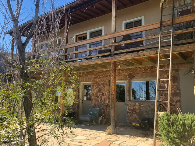 a view of a house with a small yard and potted plants