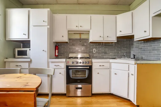 a kitchen with a stove top oven sink and cabinets