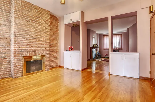 a view of a livingroom with wooden floor and kitchen space