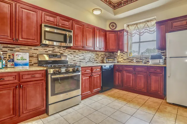 a kitchen with stainless steel appliances granite countertop a stove sink and cabinets