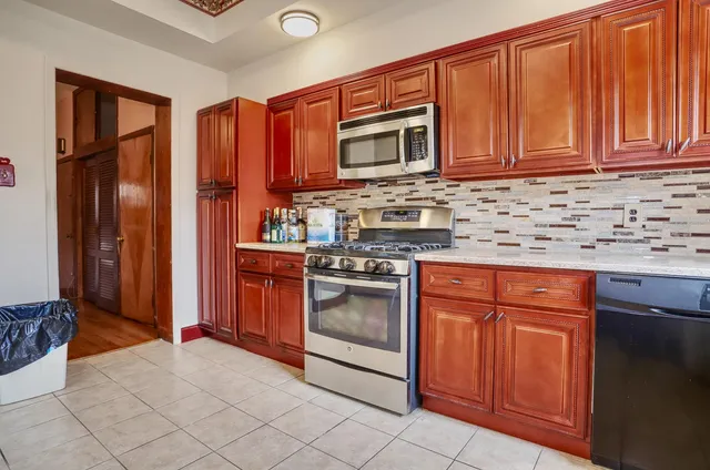 a kitchen with stainless steel appliances granite countertop a stove top oven microwave and cabinets