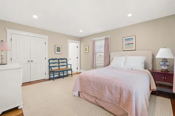 a spacious bedroom with a bed and a lamp