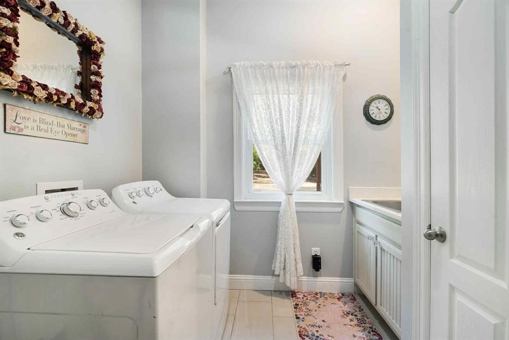 2205 County Road Blossom, TX 75416 - Photo 21 of 27 Washroom with light tile patterned floors and washing machine and clothes dryer
