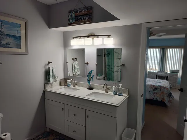 a bedroom with a bed chairs and a large window